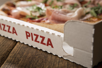 Detail van afhaalcontainer met pizza geschreven en met pizza erin