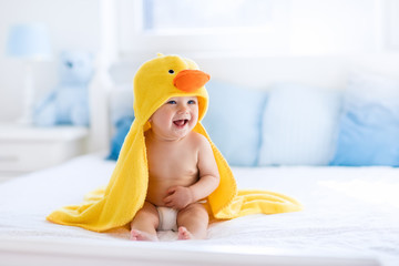 Cute baby after bath in yellow duck towel - obrazy, fototapety, plakaty