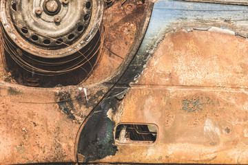 Close up detail of abandoned rusty burnt car wreck.