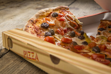 Dettaglio cartone pizza con peperoni e olive