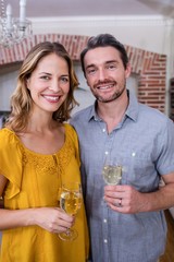 Portrait of a couple standing with a glass of wine