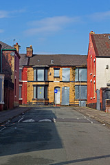 A street of boarded up derelict houses awaiting regeneration in Liverpool UK - 107503292