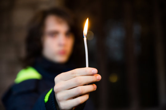 Close-up of hands holding candles