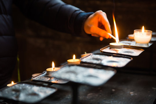 Close-up of hands lighting candles