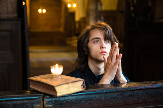 Young Man Praying and Meditating in a Church