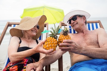 Happy senior couple relaxing on deckchairs