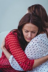 Depressed woman embracing her friend