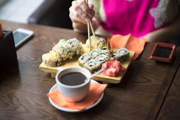 Photo female hands holding chopsticks for sushi