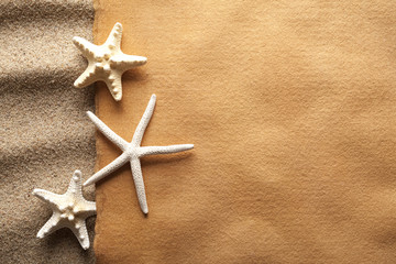 Starfishes and handmade paper sheet on beach