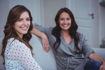Portrait of two beautiful woman sitting on sofa