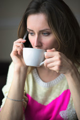 Young girl, sitting in a cafe with cup of coffee