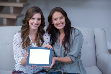 Two beautiful woman holding digital tablet