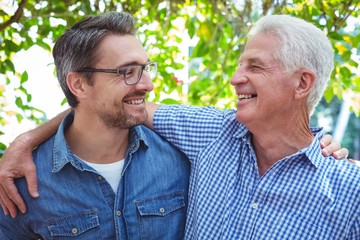 Cheerful father and son with arm around