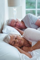 Fototapeta na wymiar Senior couple relaxing on bed 