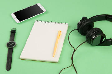 Smartphone, notepad, headphones, pen and watch