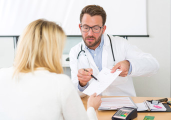 Young attractive doctor giving prescription to a patient