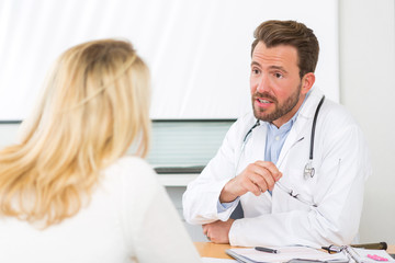 Fototapeta premium Young attractive doctor listening his patient