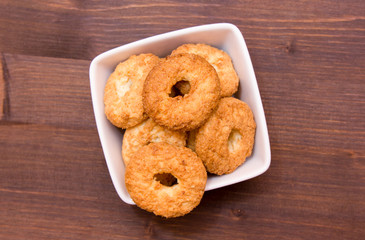Cookies on a square bowl on wooden table seen from above