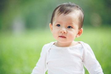 Baby looking away in garden (soft focus on the eyes)