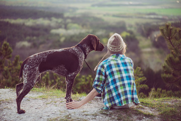 Woman and her dog posing outdoor. Active lifestyle with dog. 