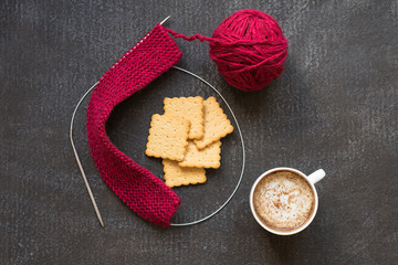 Knitting, cup of coffee and five crackers
