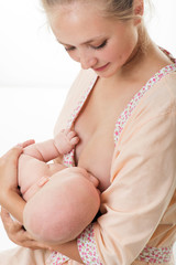 Young mother breastfeeds her baby. Breast-feeding.