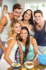 Happy young friends making breakfast at home