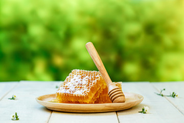 Sweet honeycomb and dipper, white wooden background