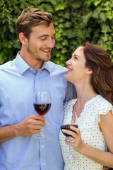 Happy couple looking at eachother while holding wineglasses