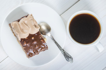 piece of chocolate cake and cup of coffee on a background of whi