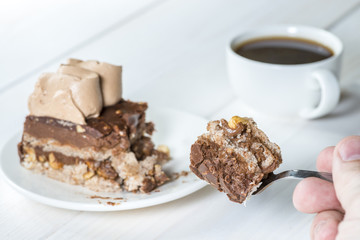 hand holding a fork with a piece of cake