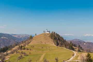 Fototapeta na wymiar Ljubljana, Slovenia - March 19, 2016. The Sv. Jakob hill (806m) in the Polhov Gradec Hill Range with 16th century church of St. James on the top.