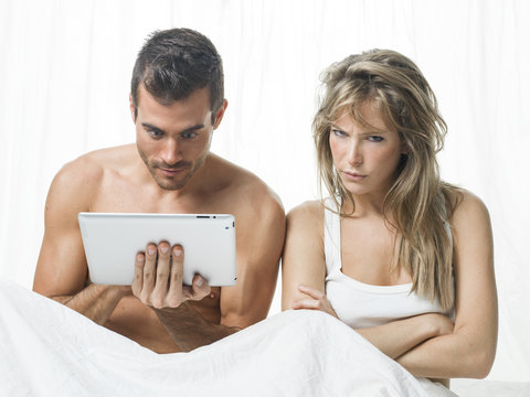 uncommunicative couple on bed in white 