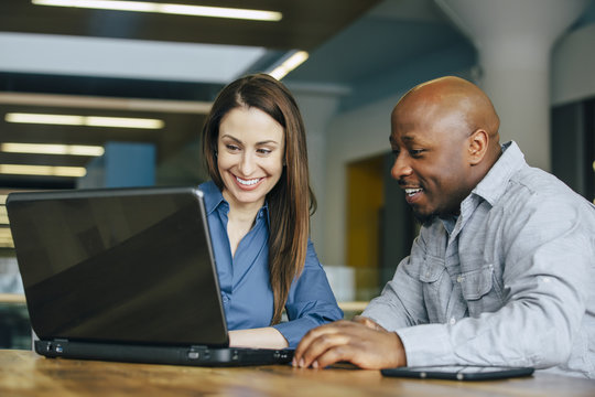 Business people using laptop in office