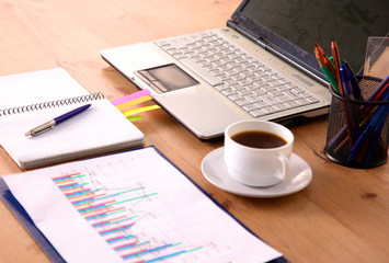 Laptop with stack of folders on table on white background