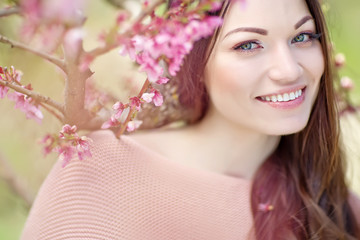 Fototapeta premium woman in a spring peach garden 