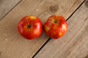 Red apples on a wooden plate on the table