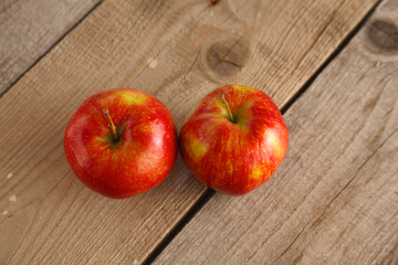 Red apples on a wooden plate on the table
