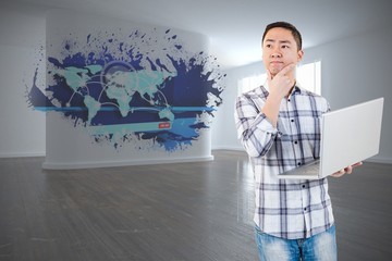 Fototapeta premium Composite image of thoughtful man holding laptop