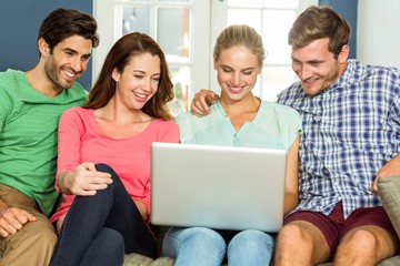 Friends using laptop at home