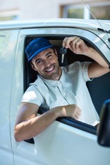 Portrait of smiling delivery man showing car keys 