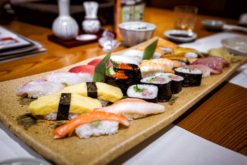 Тарелка с набором разных видов традиционных суши в японском ресторане