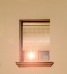 Hitzeschutz durch Rollladen - Fenster mit sich spiegelnde Sonne am Altbau
