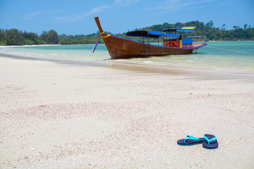 Take off your shoes on the beach with boat