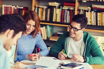 students preparing to exam and writing in library