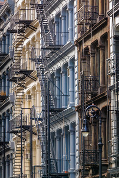 Painted cast iron facades in Manhattan's Soho neighbourhood with columns and fire escapes, New York City