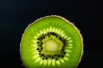 slice of kiwi fruit on black background horizontal. space for te