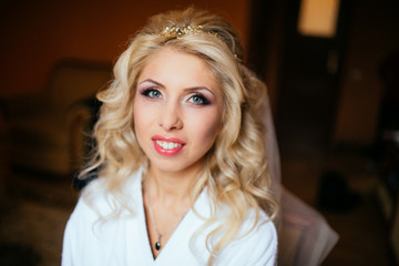 Fototapeta premium Professional makeup artist getting ready blonde bride for weddin