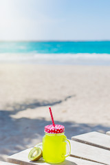 Verical photo of fresh kiwi juice and beach with the ocean