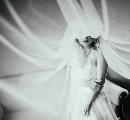 Beautiful fairytale blonde bride posing in wedding dress under v